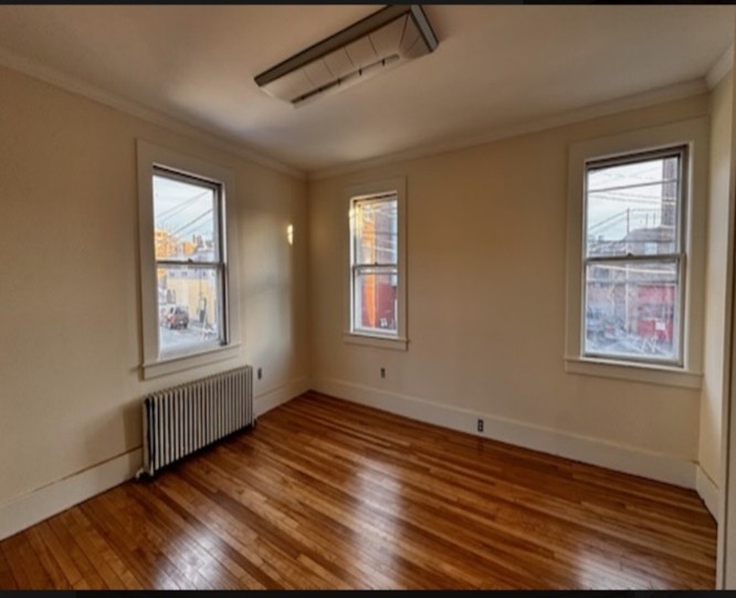 Photo of an empty room with yellow walls and hardwood flooring